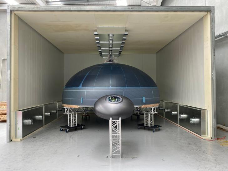 Neutron tank dome beside an Electron tank dome with a Buzz Lightyear for scale